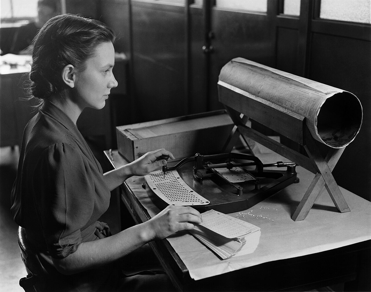 A woman at a pantograph punch transcribes census data onto a punched card